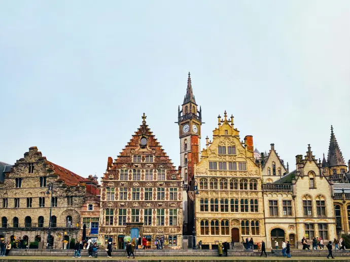 A row of buildings with a clock tower in the background